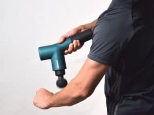 using a massage gun on arm